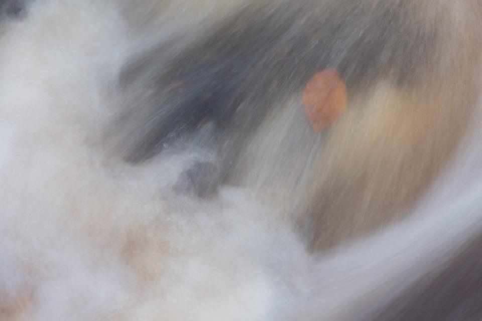 An old Autumn leaf gets trapped by the current above a small cascade at Wyming Brook in the Peak District National Park.