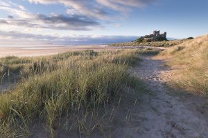 Beautiful summer sunrise at the iconic Bamburgh Castle on the North East Coast. After photographing the sunset and blue hour around Dunstanburgh we headed to Bamburgh for the sunrise. After an unpromising start the sun eventually managed to break through the low band of cloud and we got some stunning light.