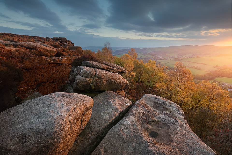 A beautiful Autumn sunset at Froggatt Edge overlooking the silver birches in the ancient woodland below. Derbyshire, Peak District National Park. Froggatt Edge is a gritstone edge above the picturesque village of Froggatt in the Peak District National Park. Often overlooked in favour of the neighbouring Curbar Edge, Frogatt is still very popular with climbers and features several famous Derbyshire routes.