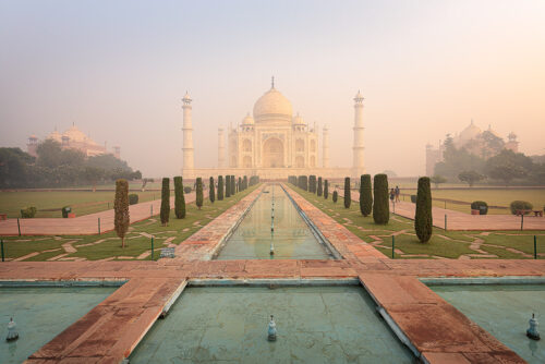 Classic view of the Taj Mahal across the landscaped lawns and fountains from the Diana bench, Agra, Uttar Pradesh, India. 