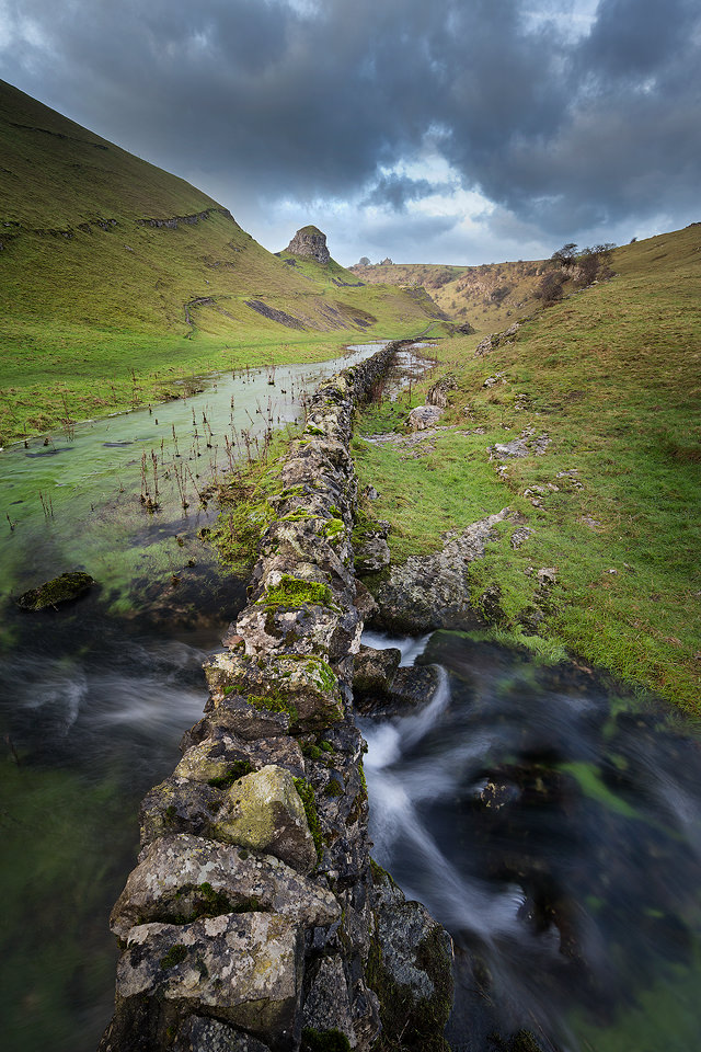 View through Cressbrook Dale looking towards the distinctive limestone stack known as the Peter's stone. This seasonal river only flows through cressbrook dale after very heavy rain. 